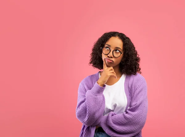 Portrait of pensive black woman touching chin and looking aside at copy space on pink studio background — Foto de Stock