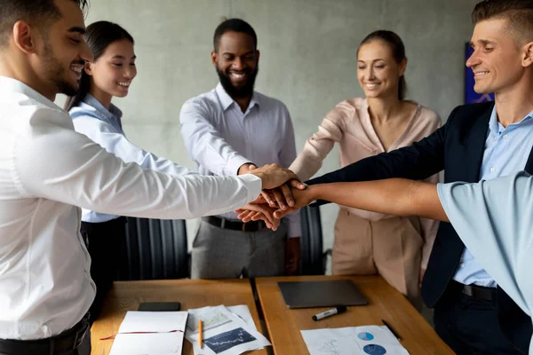 Teamwork And Unity. Group Of Multiethnic Coworkers Stacking Hands Together In Office — Foto de Stock