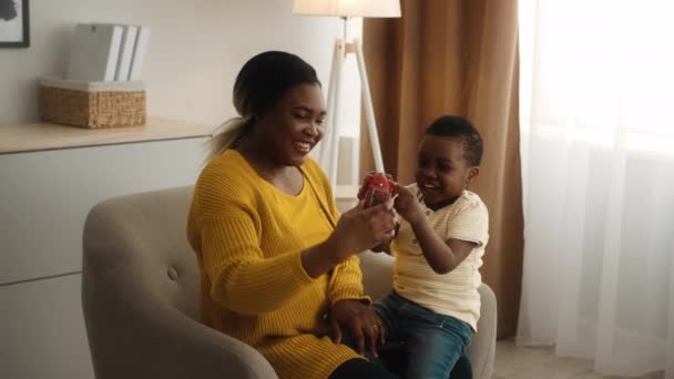 Noir mère et son petit fils jouer avec jouet voiture à la maison — Video