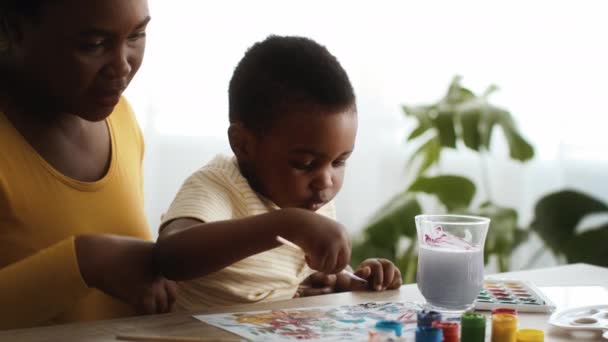 Little Black Boy And His Loving Mom Drawing With Watercolors At Home — Vídeo de Stock