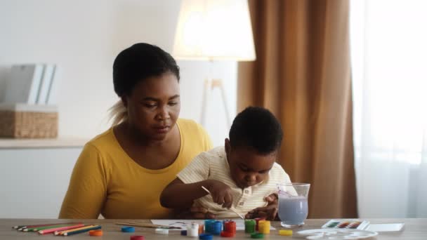 Babysitting Concept. Black Nanny And Little Preschooler Boy Drawing Together At Home — Video Stock