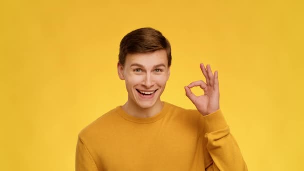 Man Gesturing Okay Sign With Hand Nodding Head, Yellow Background — Wideo stockowe