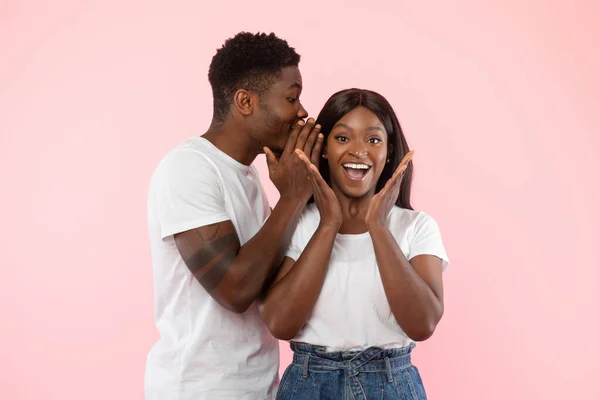 Black Man delen van nieuws met zijn opgewonden vriendin fluisteren naar oor — Stockfoto