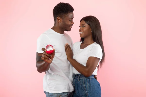 Happy black man giving engagement ring to his excited girlfriend — Stockfoto