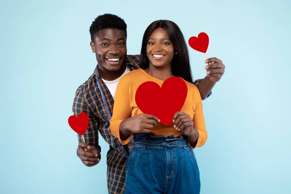 Young Romantic Black Couple Posing And Holding Red Paper Hearts — Foto Stock