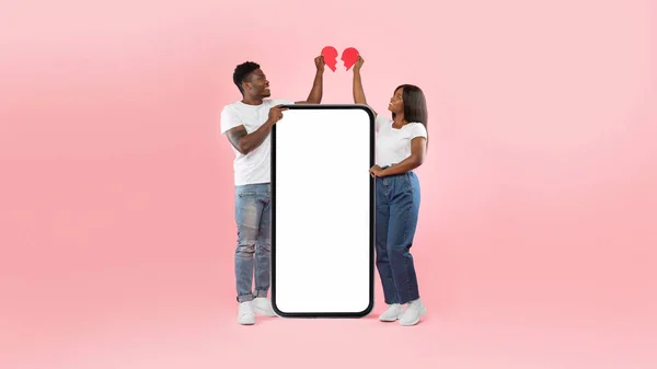 Black couple connecting two halves of broken heart, mockup screen — стоковое фото