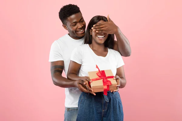 Happy black man making surprise for his woman giving box — стоковое фото
