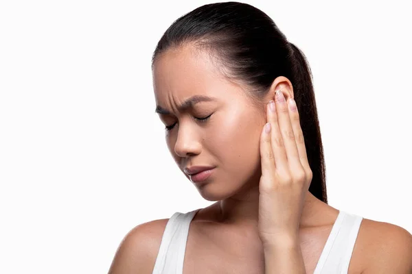 Asian woman having ear pain, white studio background — 스톡 사진