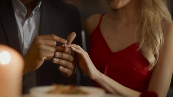 Negro hombre proponiendo a novia poner compromiso anillo en restaurante — Vídeos de Stock