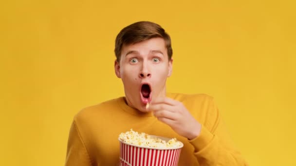 Shocked Guy Watching Movie And Eating Popcorn Over Yellow Background — Vídeo de Stock