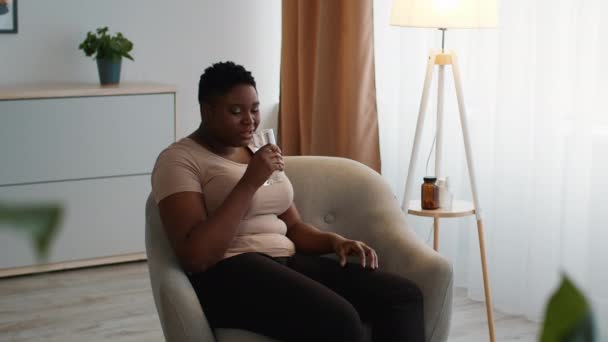 Overweight Black Woman Choking Drinking Water From Glass At Home — Stockvideo