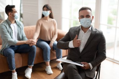 Mutlu çift terapi seansında barışıyor, terapistler onaylıyor.