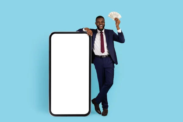 Earn Online. Black Businessman With Cash In Hand Standing Near Blank Smartphone — Stockfoto