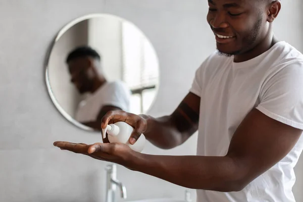 Negro chico usando líquido jabón de botella en moderno cuarto de baño — Foto de Stock