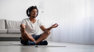 Meditasyon pratiği. Rahat Siyah Adam Lotus Konumunda Evde Meditasyon Yapıyor