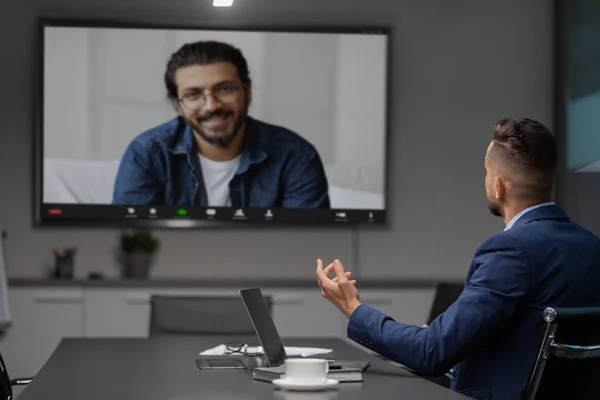 Middle eastern businessman having video chat with employee at office — Stock Photo, Image