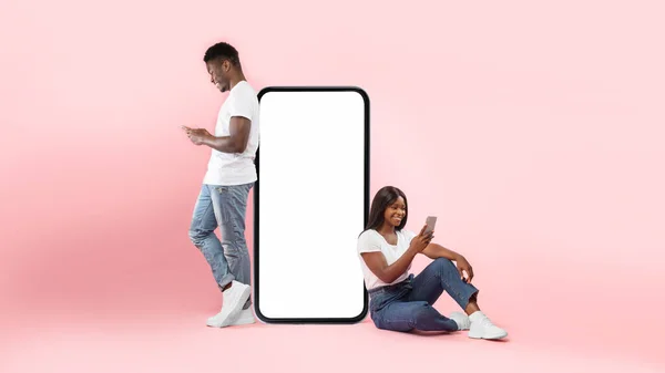 Couple showing white empty smartphone screen and texting — Fotografia de Stock
