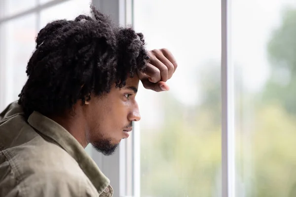 Melancolía otoñal. Primer plano disparo de reflexivo joven negro chico mirando por la ventana — Foto de Stock