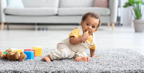 Seguridad del bebé. Adorable niño negro mordiendo corcho de vino encontrado en el piso —  Fotos de Stock