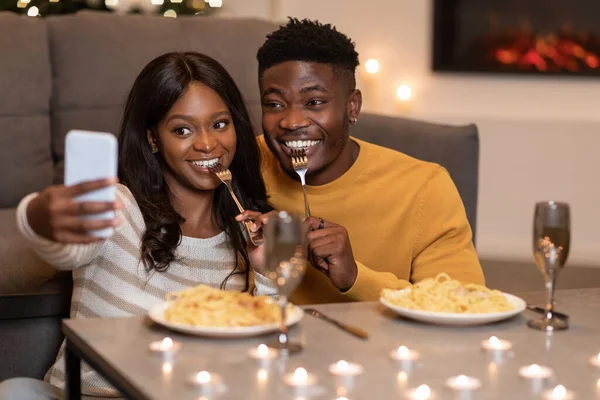 使用智能手机的非洲夫妻在家庆祝情人节 — 图库照片