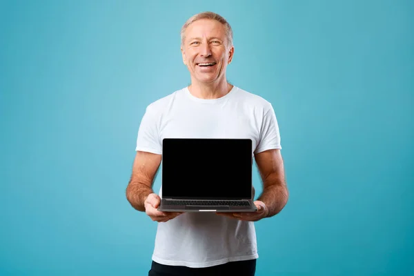 Happy mature man showing black empty pc screen — Stock Fotó
