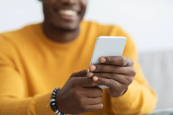 Unrecognizable black guy using mobile phone at home — Foto de Stock