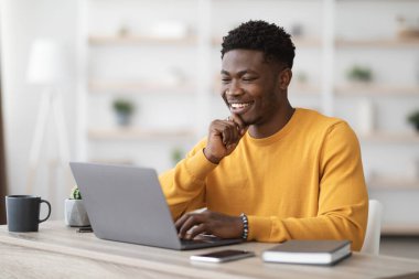 Laptop klavyesinde yazan mutlu siyah adam proje yöneticisi
