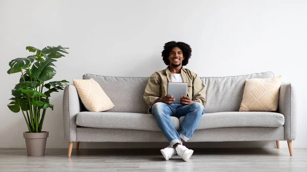 Millennial African American Guy Resting With Digital Tablet On Couch — Fotografia de Stock