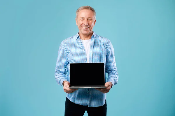 Boldog érett férfi bemutató fekete üres laptop képernyő — Stock Fotó