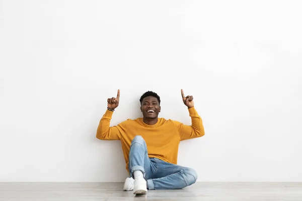 Joyful black man pointing up at copy space on white — Fotografia de Stock