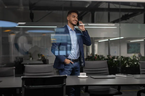 Handsome middle eastern businessman talking on phone in office