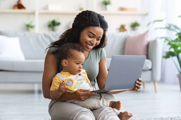 Happy Black Mother And Little Infant Son Using Laptop Computer At Home — стоковое фото