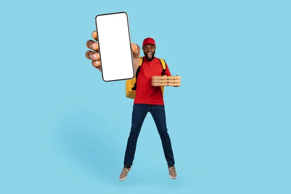 Food Delivery App. Black Courier Guy With Pizza Boxes Showing Blank Smartphone