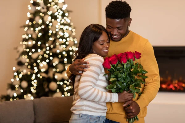 African Husband Congratulating Wife On Christmas Giving Roses At Home — Stock fotografie