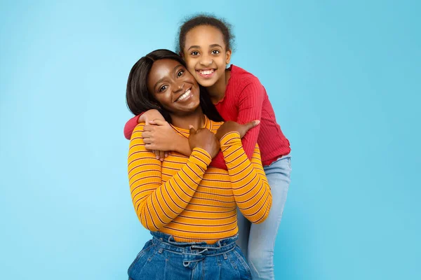 Αφρο-Αμερικανίδα που αγκαλιάζει τη χαμογελαστή μαμά της από πίσω — Φωτογραφία Αρχείου