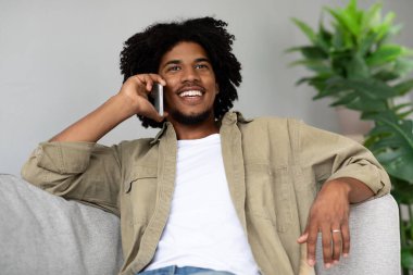 Memnun oldum. Mutlu gülümseyen Afrikalı Amerikalı Cep telefonuyla konuşuyor