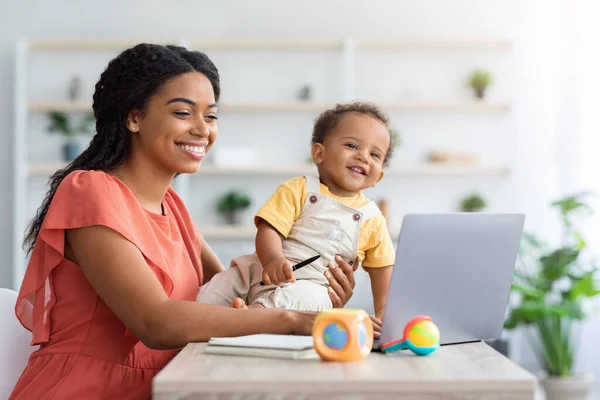 Portrait Of Happy Black Woman With Little Baby Using Laptop At Home — стоковое фото