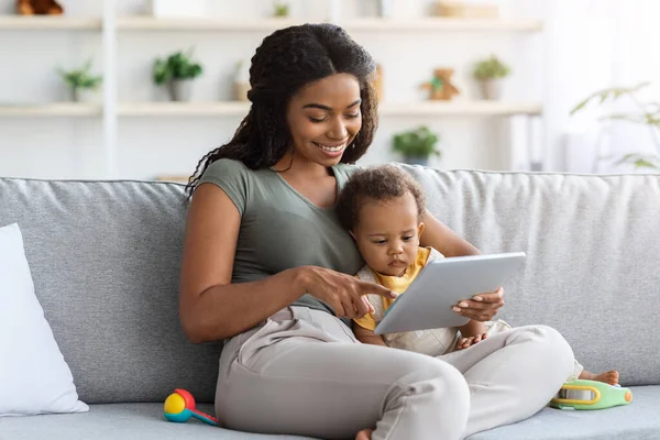 Babies And Gadgets. Happy Black Woman And Toddler Son Using Digital Tablet — стоковое фото