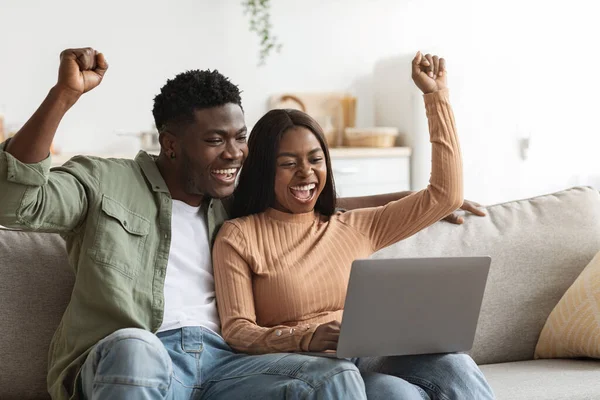 Lucky black couple trading together on Internet, home interior — Fotografia de Stock