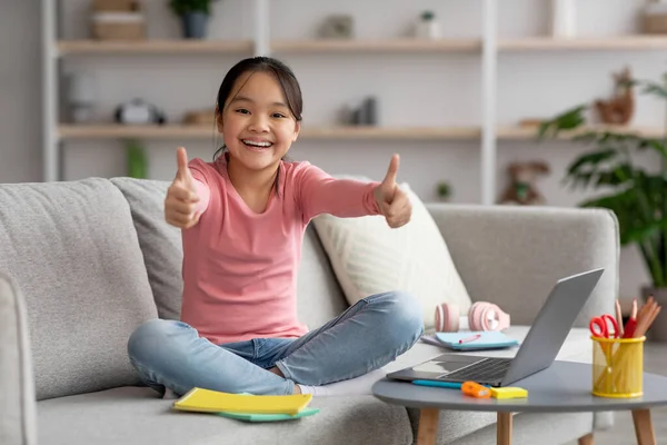 快乐的亚洲女孩在家里学习，露出大拇指 — 图库照片