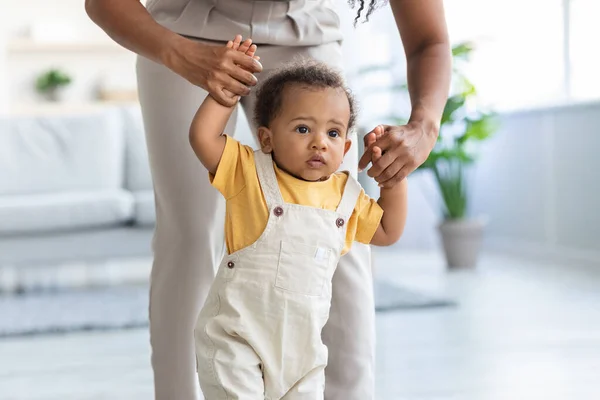 Portrait Of Adorable Black Infant Walking With Mothers Help In Room — Stock Fotó