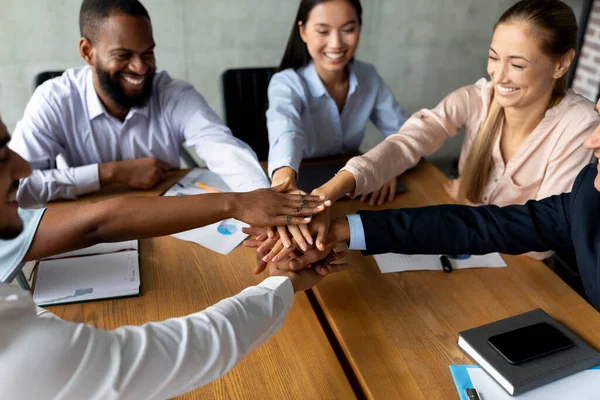 Teambuilding Concept. Happy Multiethnic Coworkers Stacking Hands Together During Meeting In Office — Stock Fotó