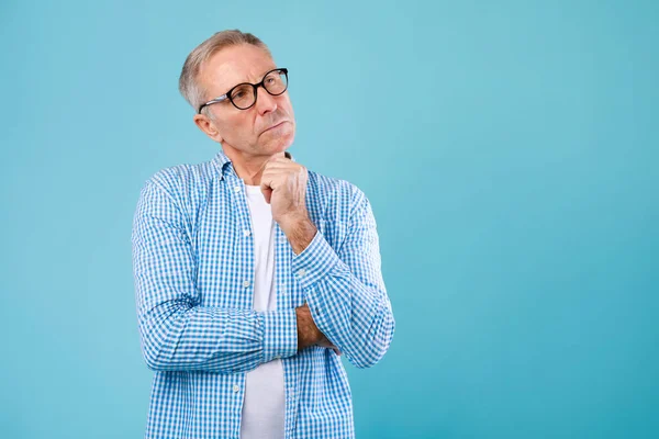 Portrait of pensive mature man looking up at studio — Stock Fotó