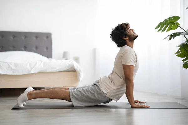 Happy athletic indian man stretching his body at home — Foto de Stock