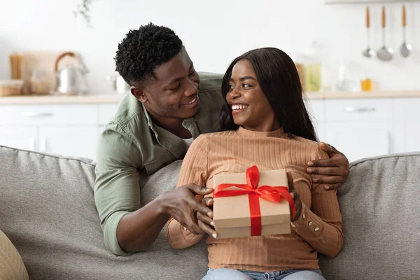 Amoroso hombre afroamericano abrazando a su esposa, dando regalo —  Fotos de Stock