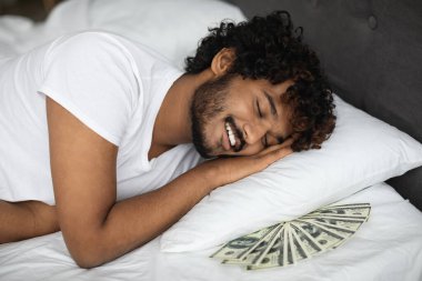 Rich indian man sleeping with lots of cash