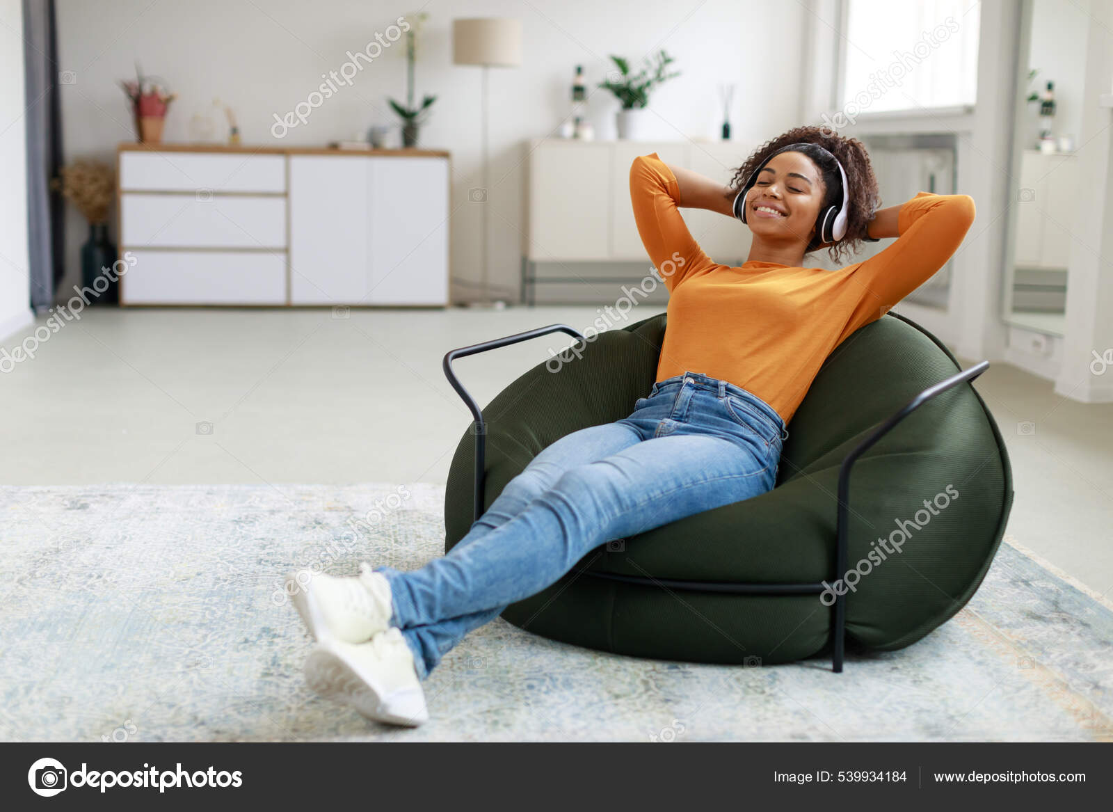 Calm black woman having rest at home on bean bag Stock Photo Milkos 539934184