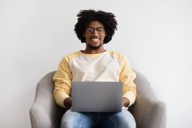 Online Education. Smiling Black Male Wearing Eyeglasses Study With Laptop At Home