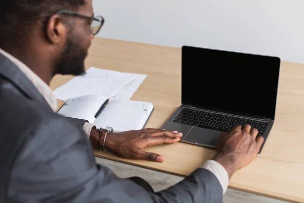 Тисячолітній чорний підприємець, який працює на ноутбуці з порожнім екраном в офісі, макет для веб-сайту — стокове фото