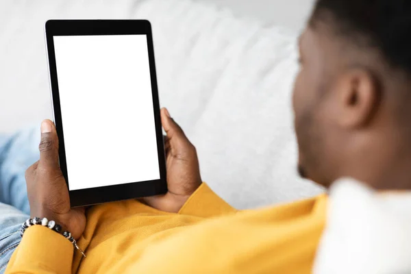 Unrecognizable black guy using digital tablet with empty screen — 图库照片